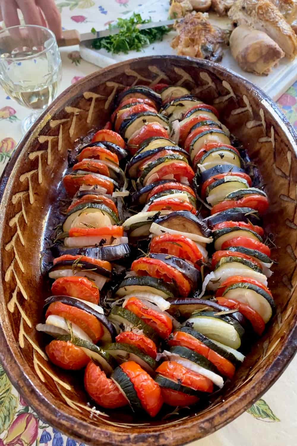 tian dish of layered roasted summer vegetables - tomato, aubergine, zucchini and onion with herbs