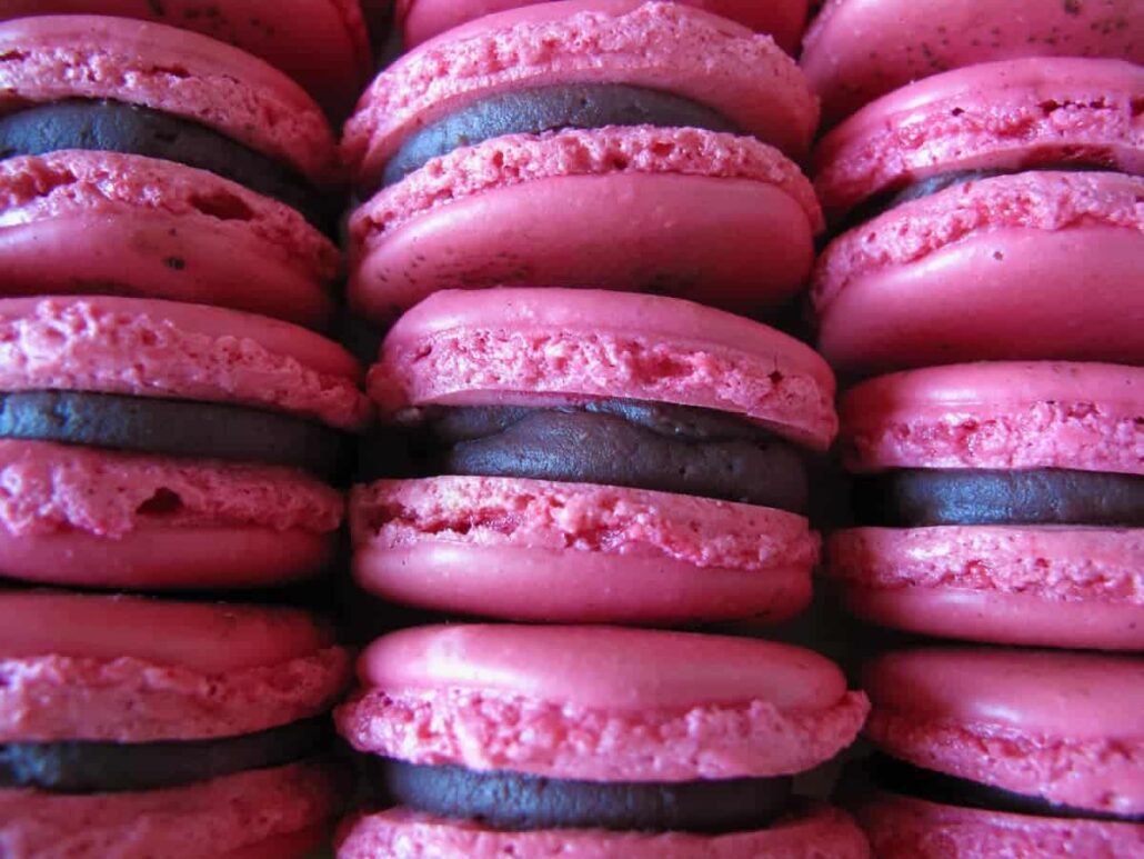 close up of pink and chocolate macarons