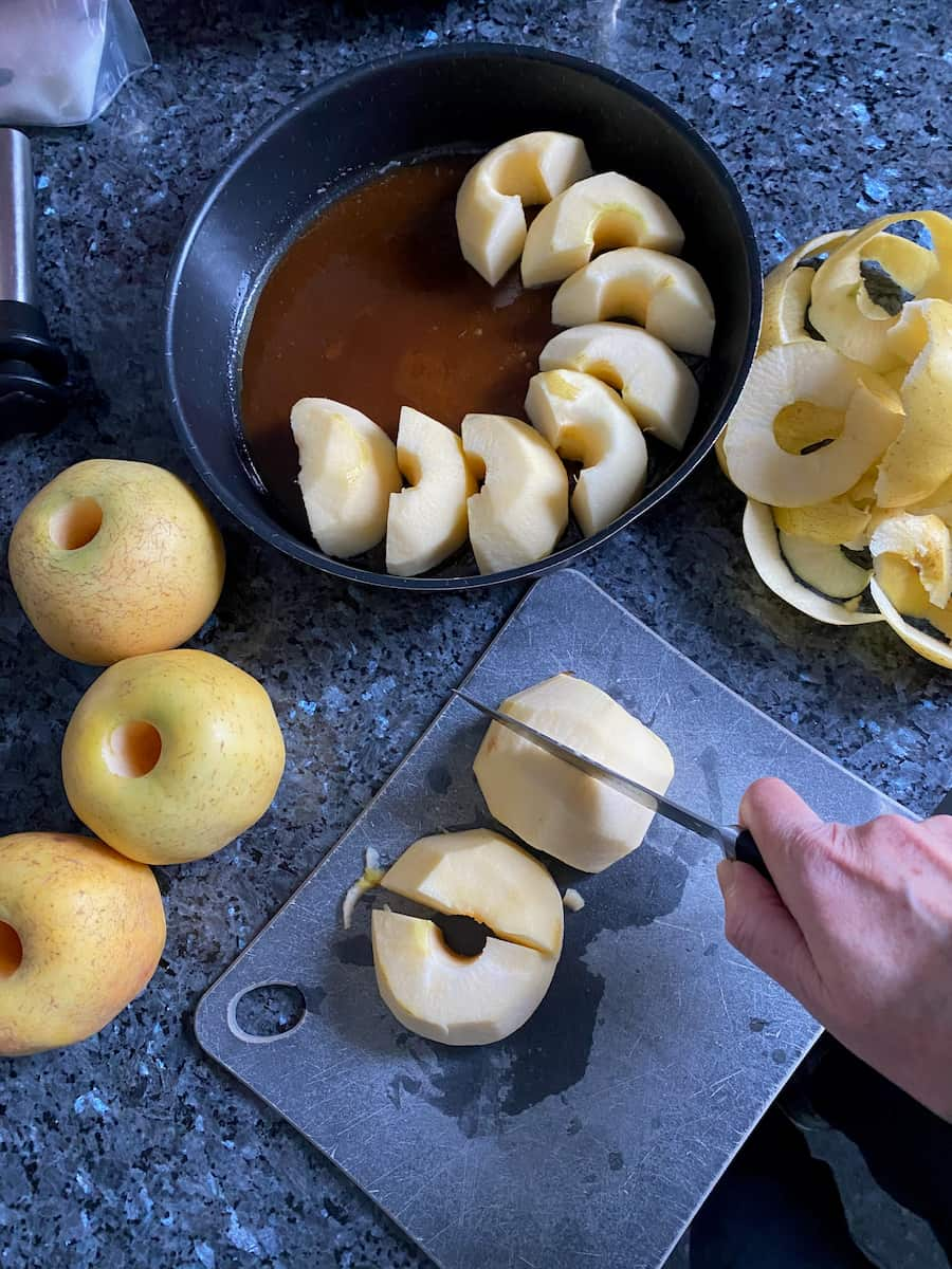 cutting apples for a tarte tatin next to the caramel and pan