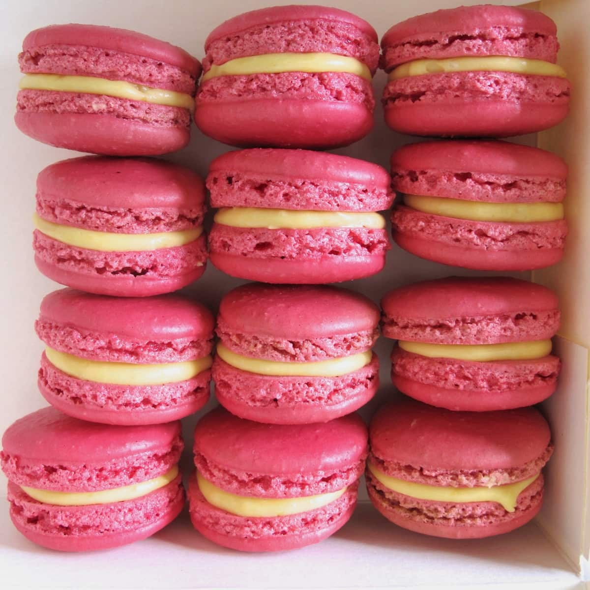 box of pink macarons with lemon yellow filling