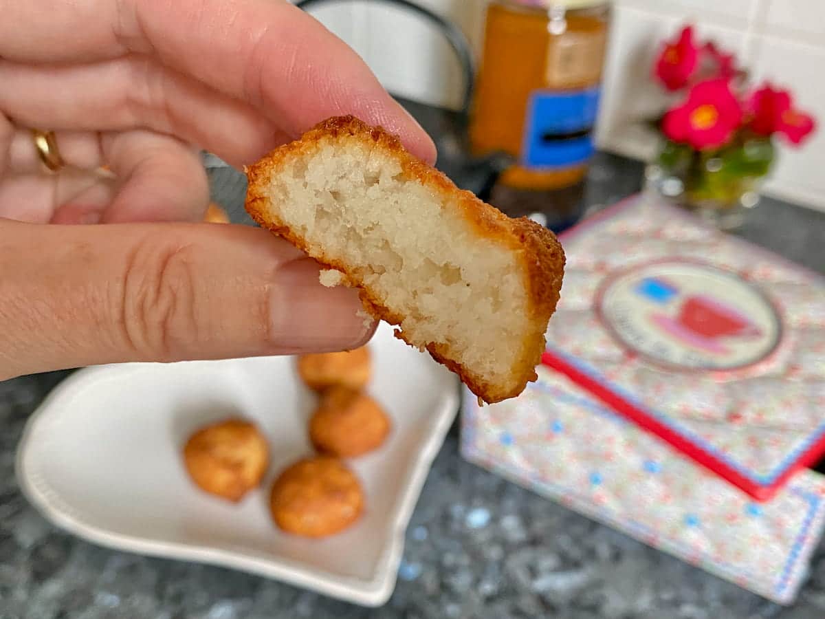 a bitten coconut macaroons showing soft and light inside and toasted crispy exterior