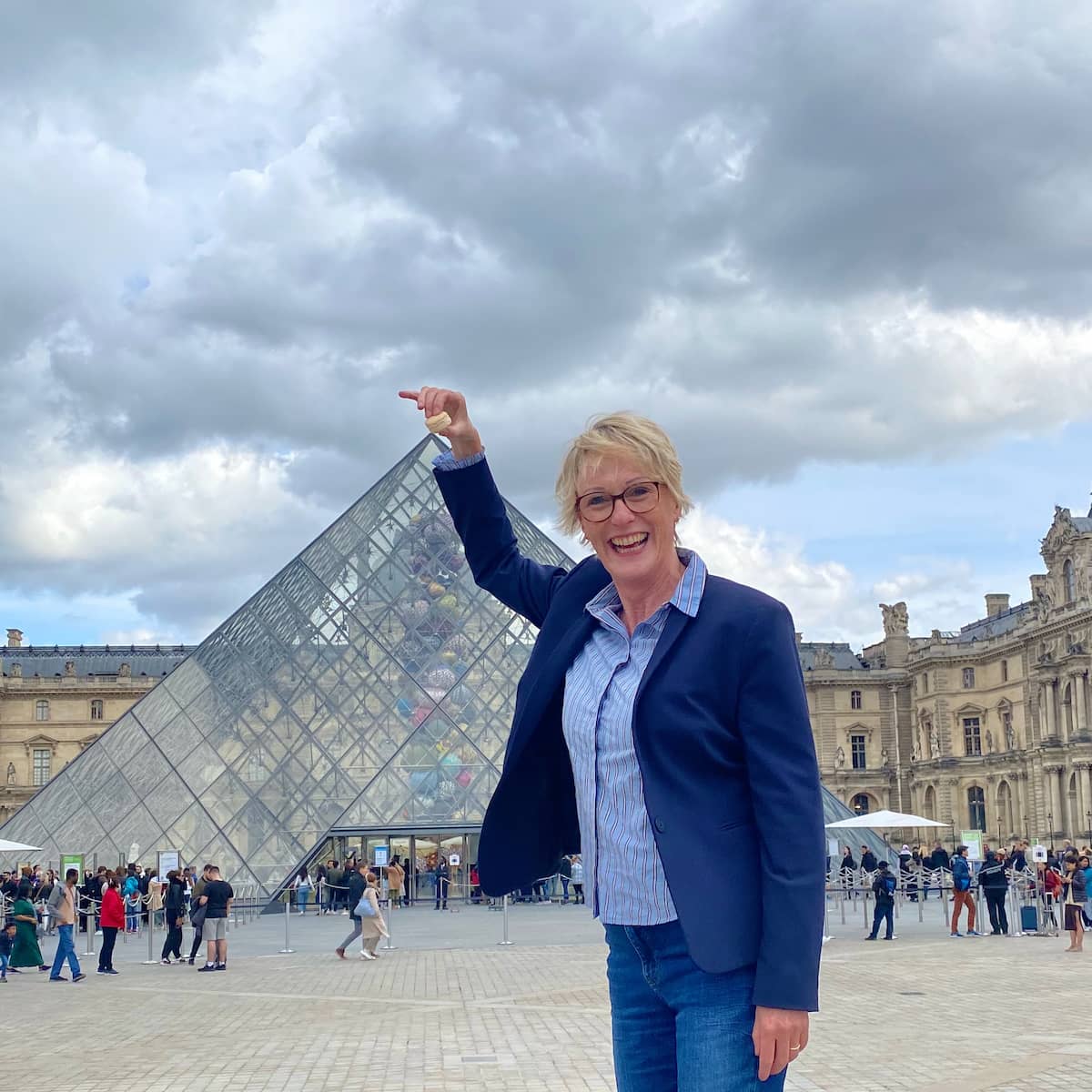 Jill Colonna at the Pyramide du Louvre in Paris with macarons