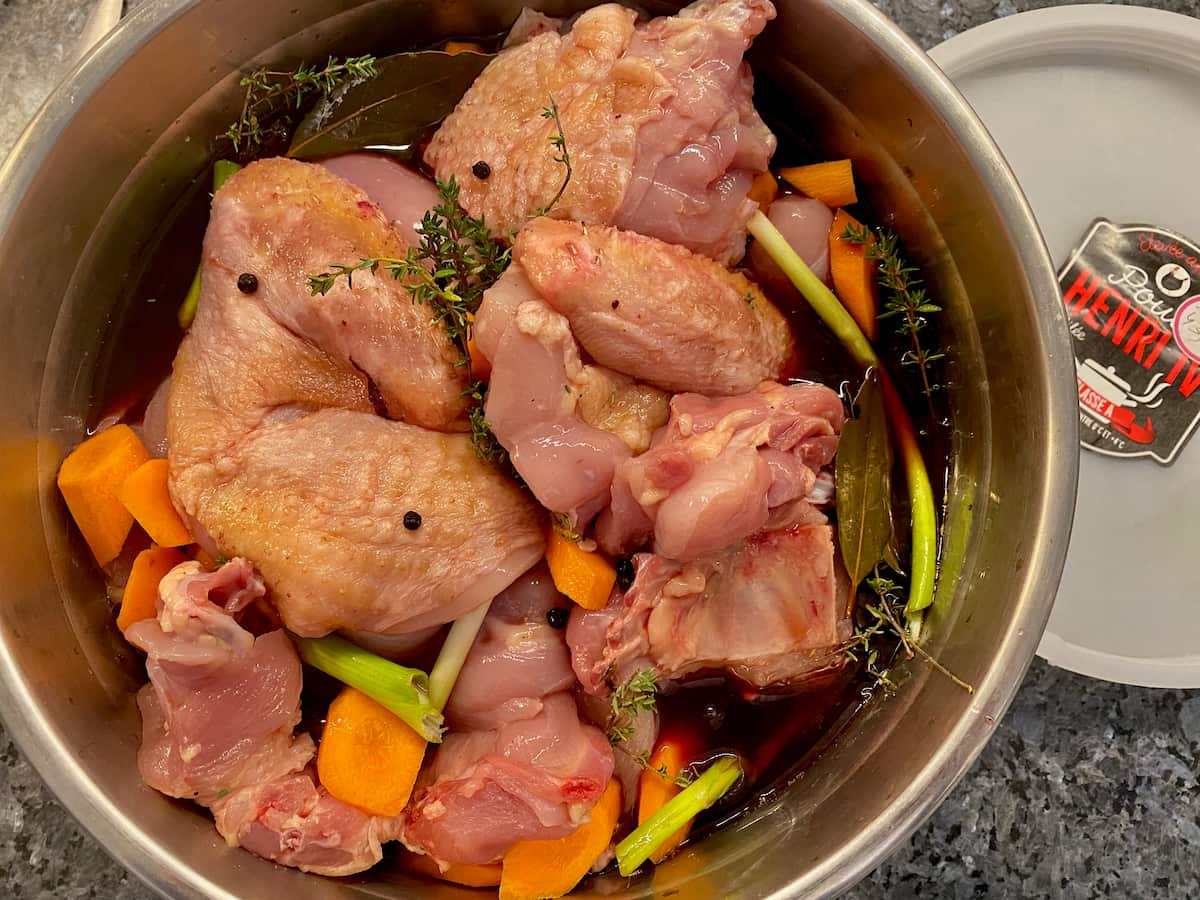 marinading pieces of chicken in red wine, carrots and herbs