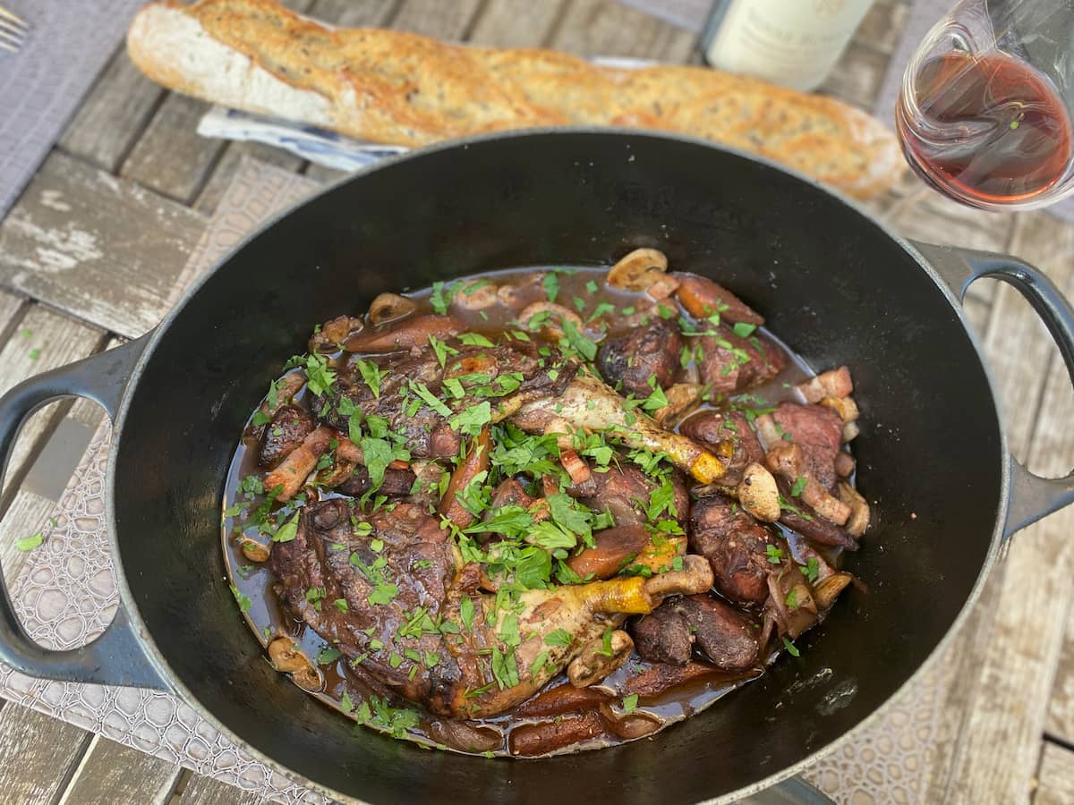 coq au vin French dish with baguette and red wine