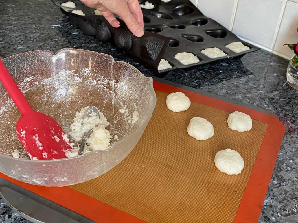 making little coconut cookies in a mould or rolling them to make rounds