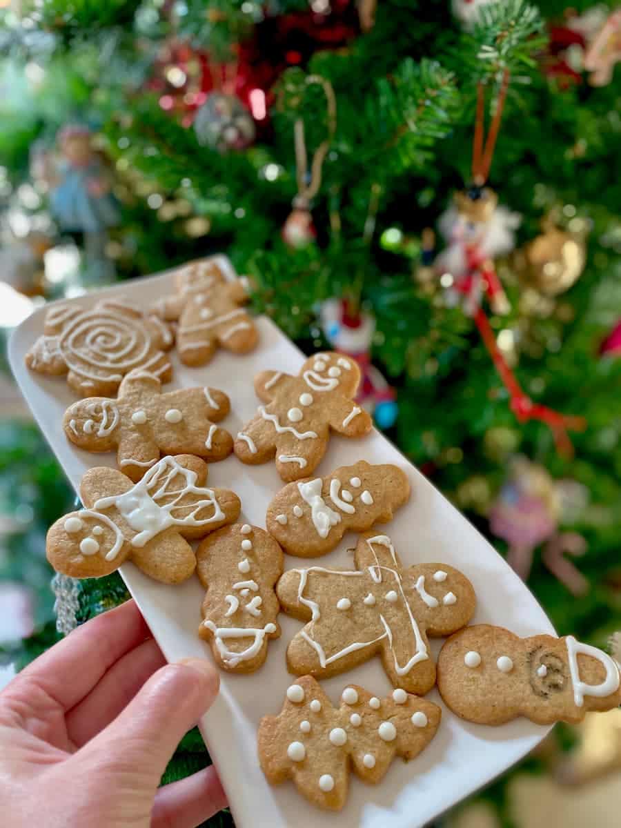 gingerbread men cookies on a plate in front of the Christmas tree