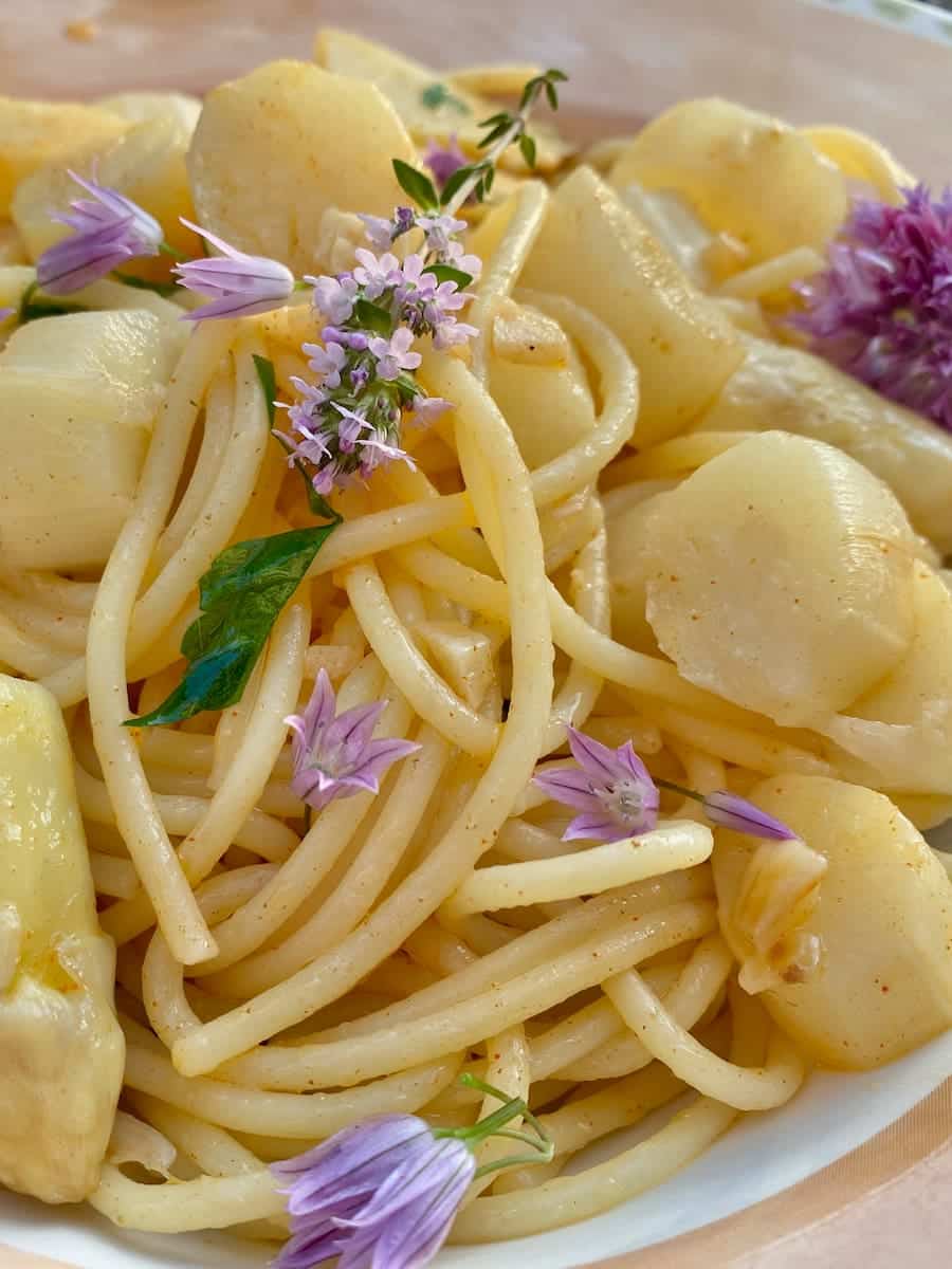 spaghetti pasta tossed in white asparagus and herb flowers