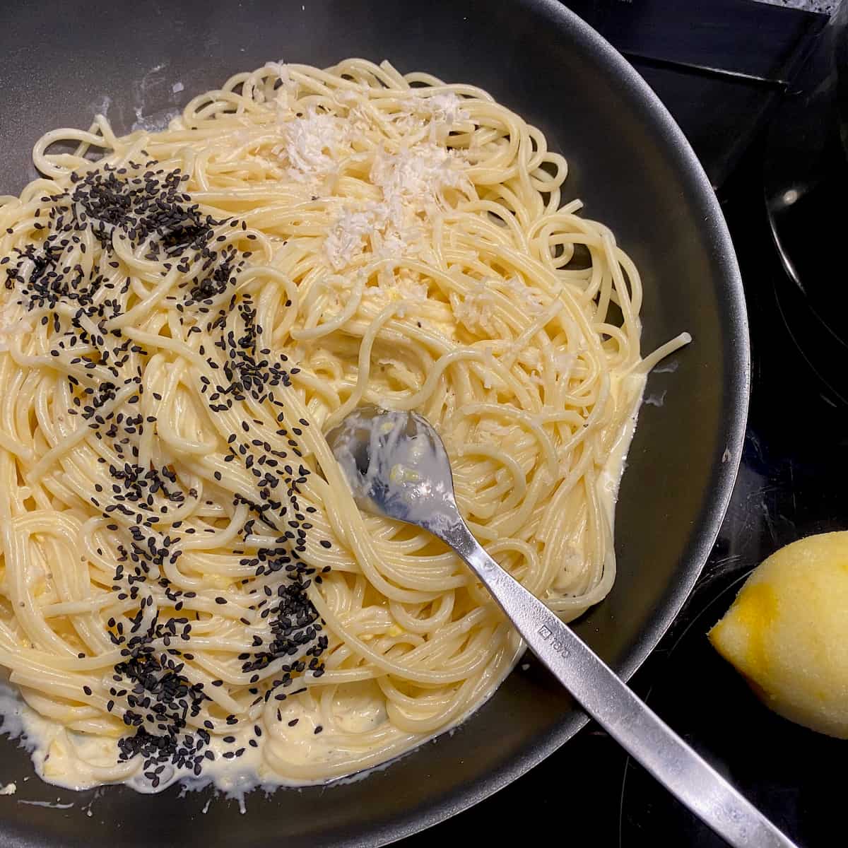 pan of cooked spaghetti, tossed with a creamy lemon pasta sauce with parmesan and poppy seeds 
