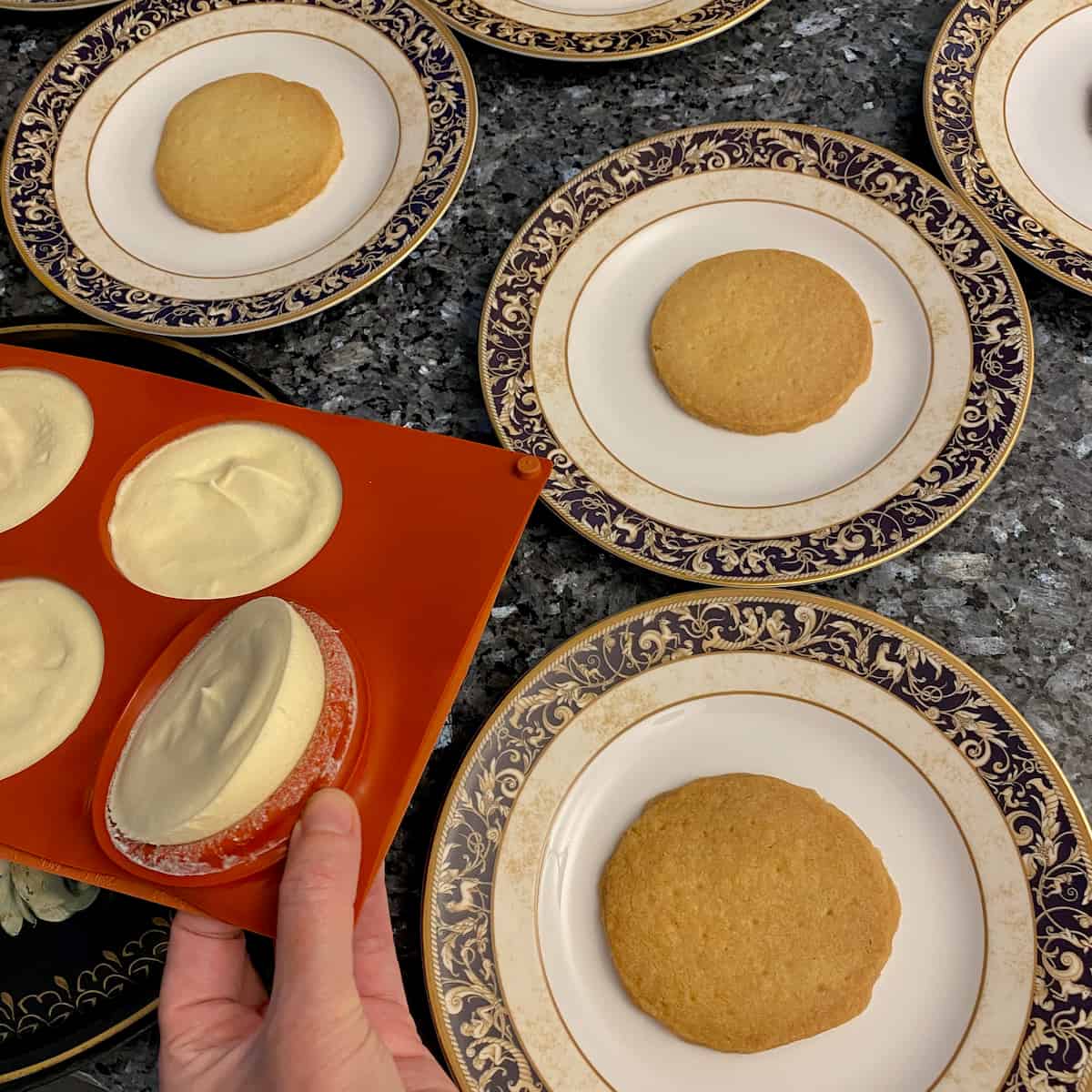 turning out parfaits from a silicone mould next to plates with thin shortbread rounds
