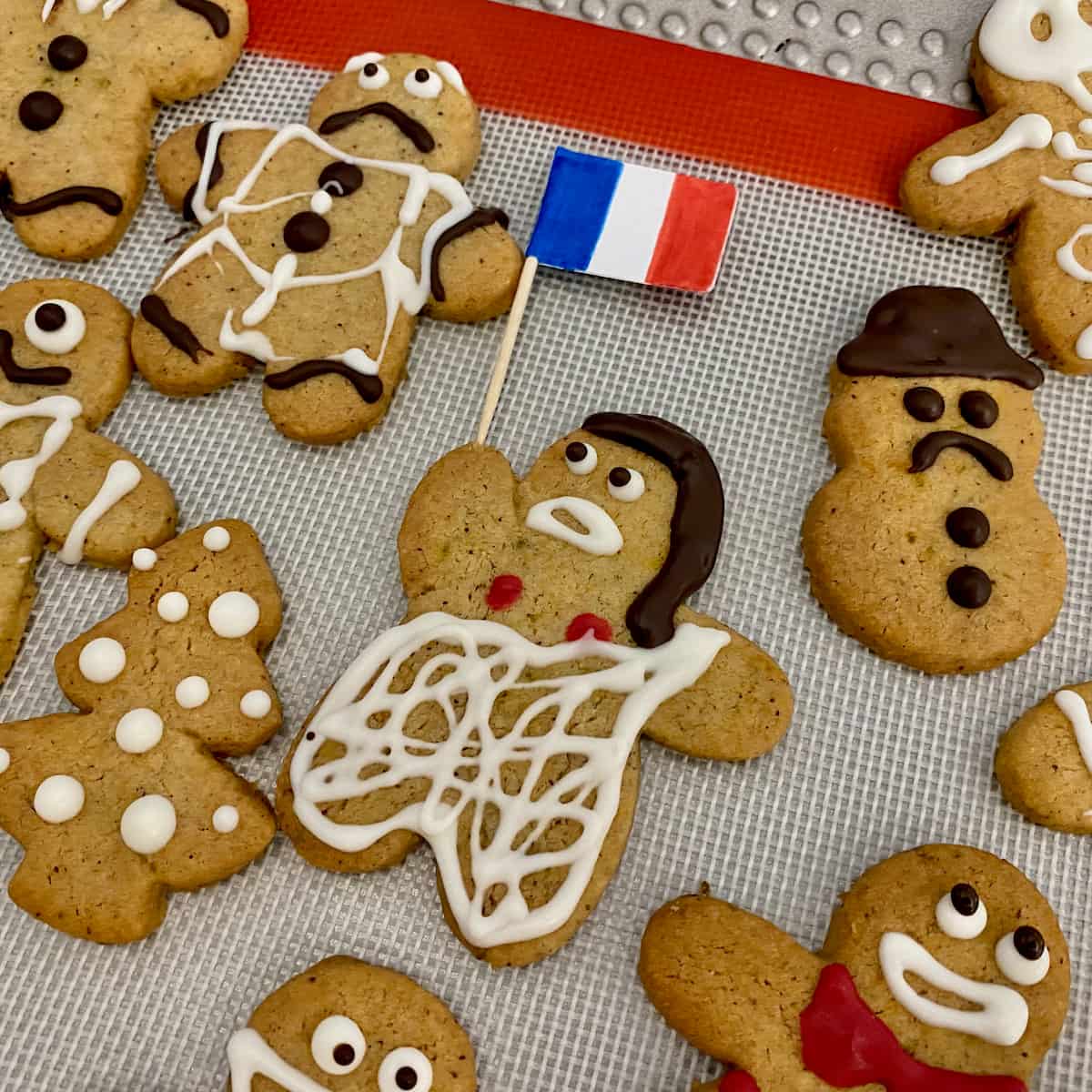 French Marianne decorated cookie holding a French flag surrounded by other gingerbread men