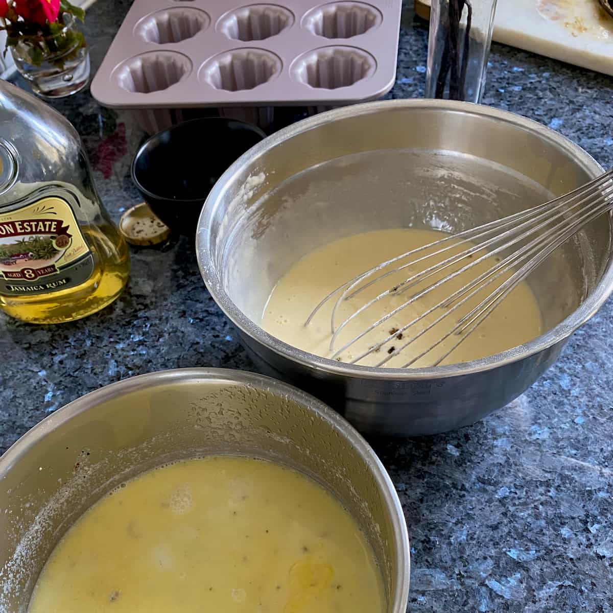 two separate bowls, mixing warmed vanilla milk and butter with egg and flour mixture