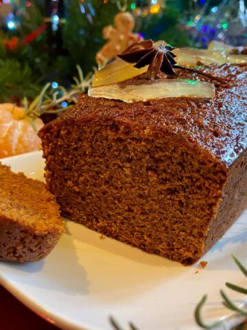 slice of glossy dark gingerbread topped with candied ginger