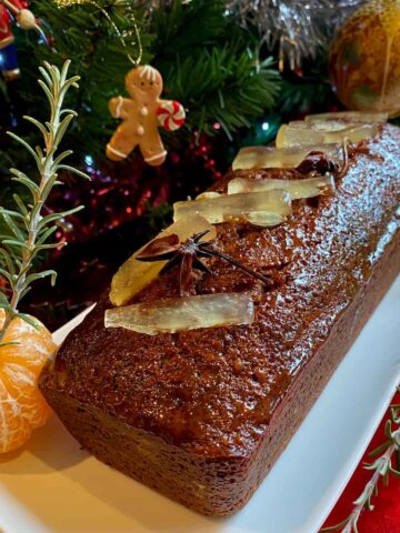 French gingerbread or pain d'épices topped with glacé fruits next to the christmas tree