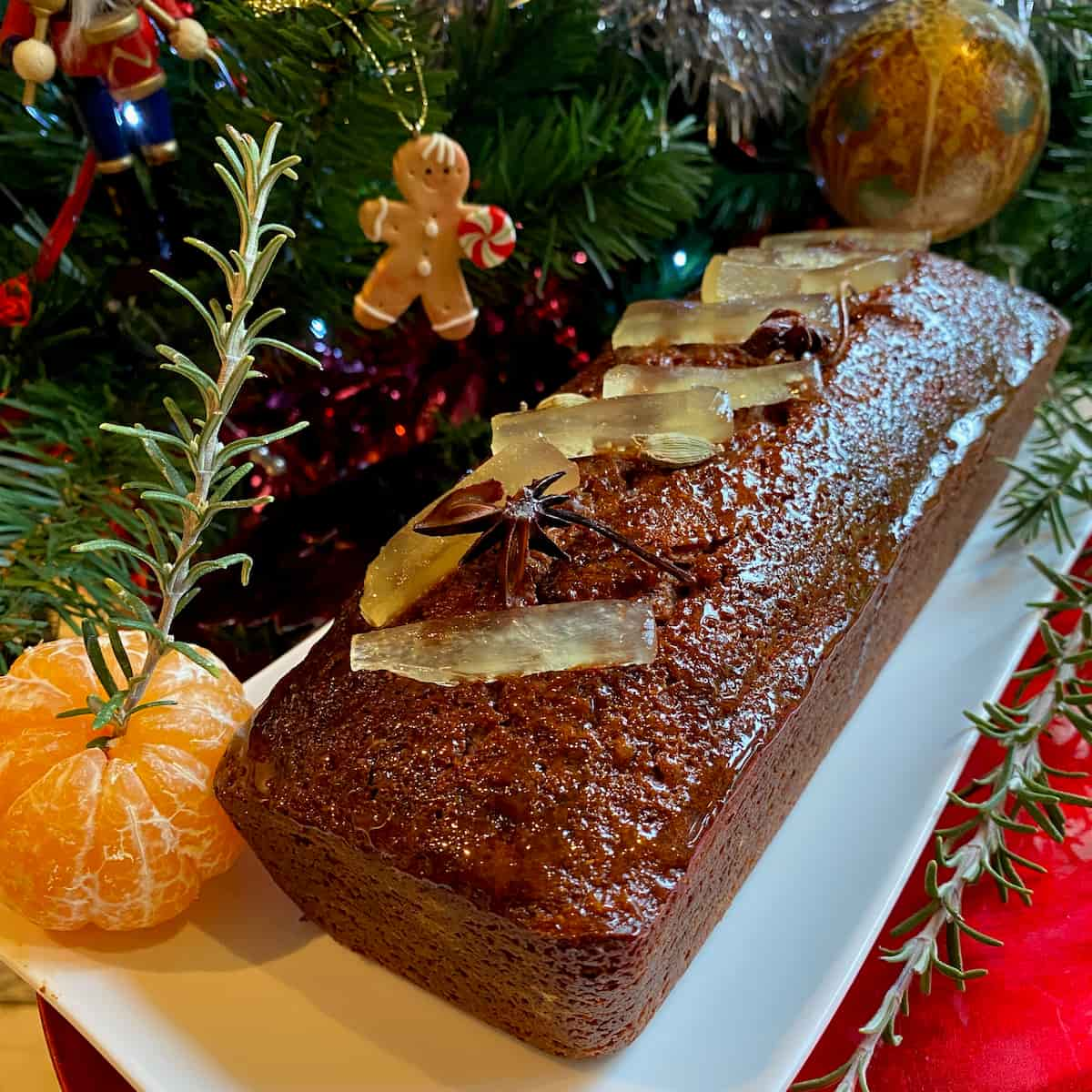 French gingerbread or pain d'épices topped with glacé fruits next to the christmas tree