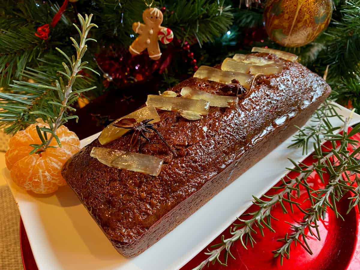 loaf of shiny pain d'épices coated in honey and candied ginger