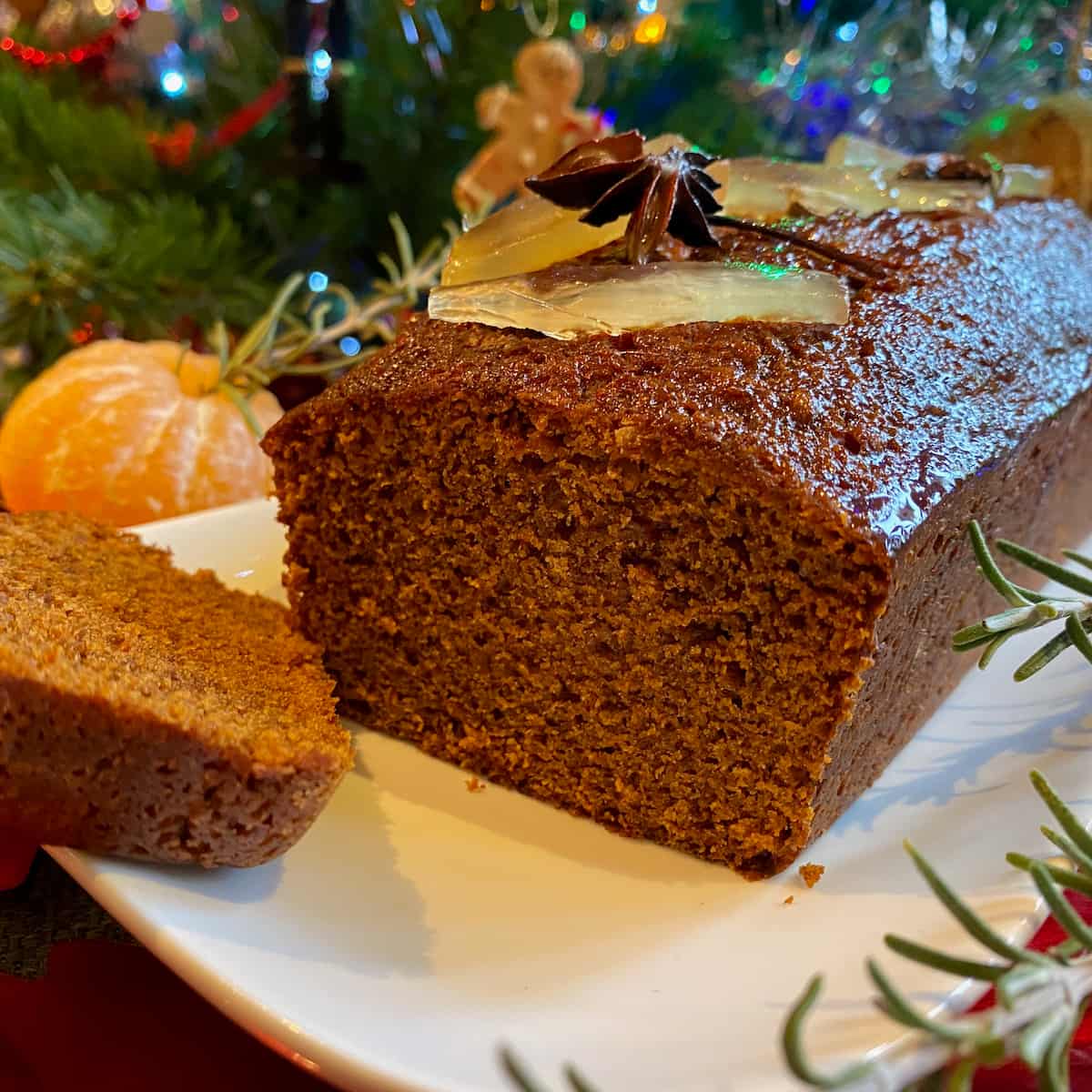 slice of glossy dark gingerbread topped with candied ginger