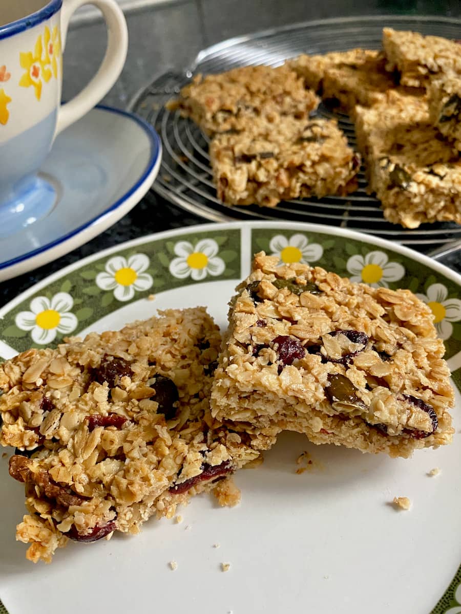 cereal bar squares on a plate showing golden oats and dried fruits