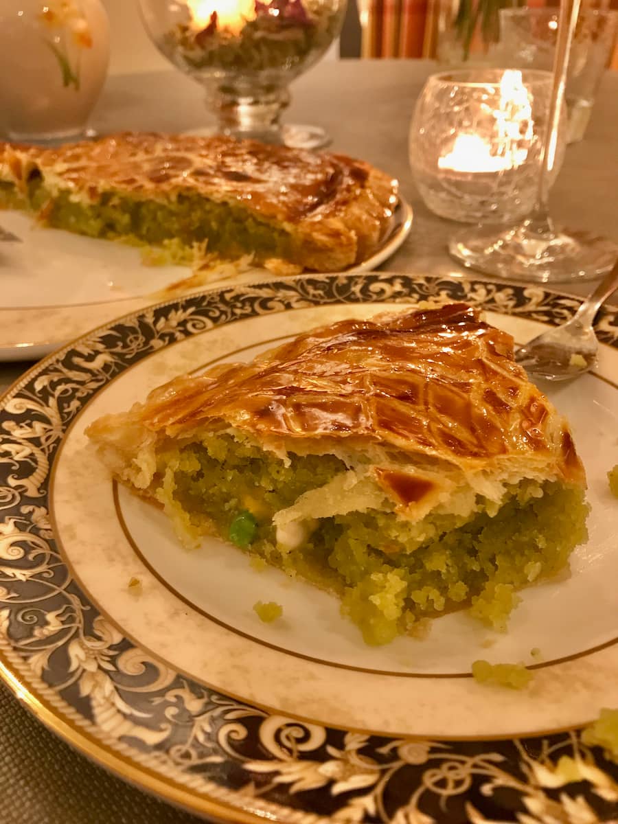 slice of puff pastry cake filled with pistachio and almond with a little trinket hidden inside