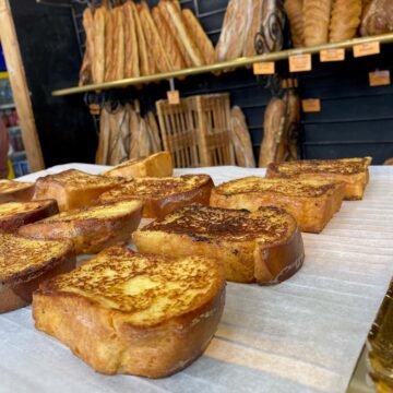 tray holding slices of toasted French toast or Pain Perdu in a boulangerie in France in front of baguettes