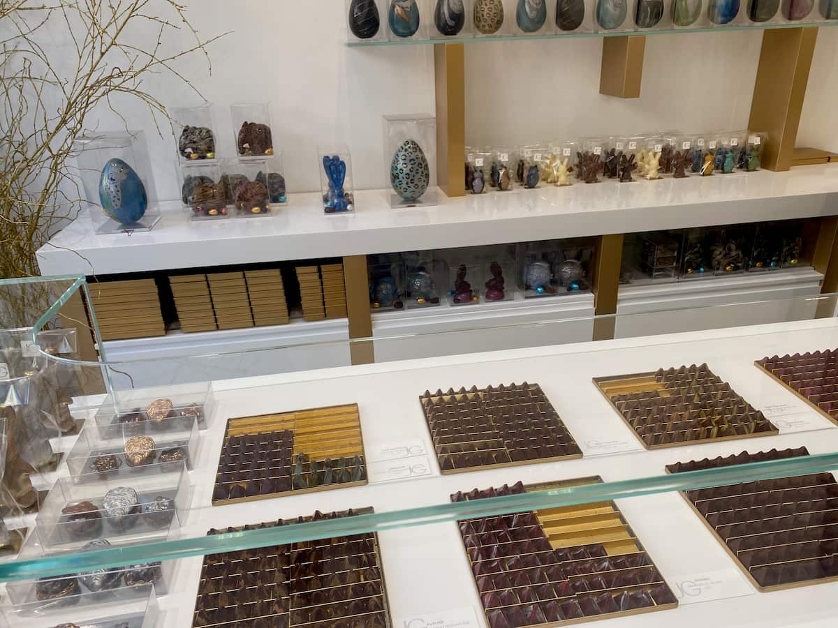 glass case with square presentations of pyramid chocolates and various Easter eggs