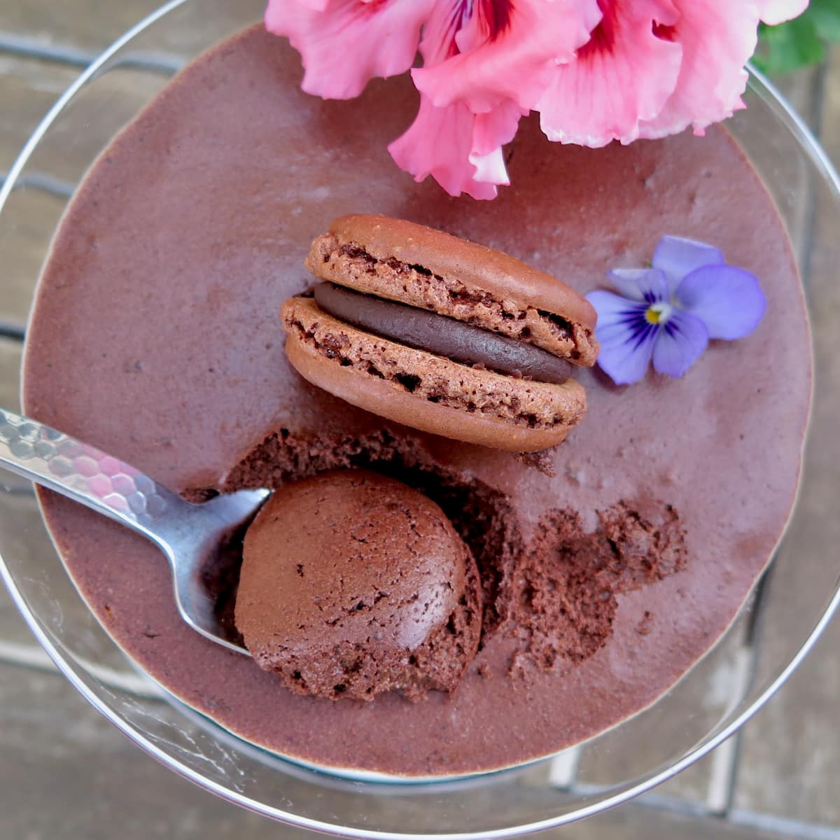 spoon into a dark chocolate mousse topped with chocolate macaron