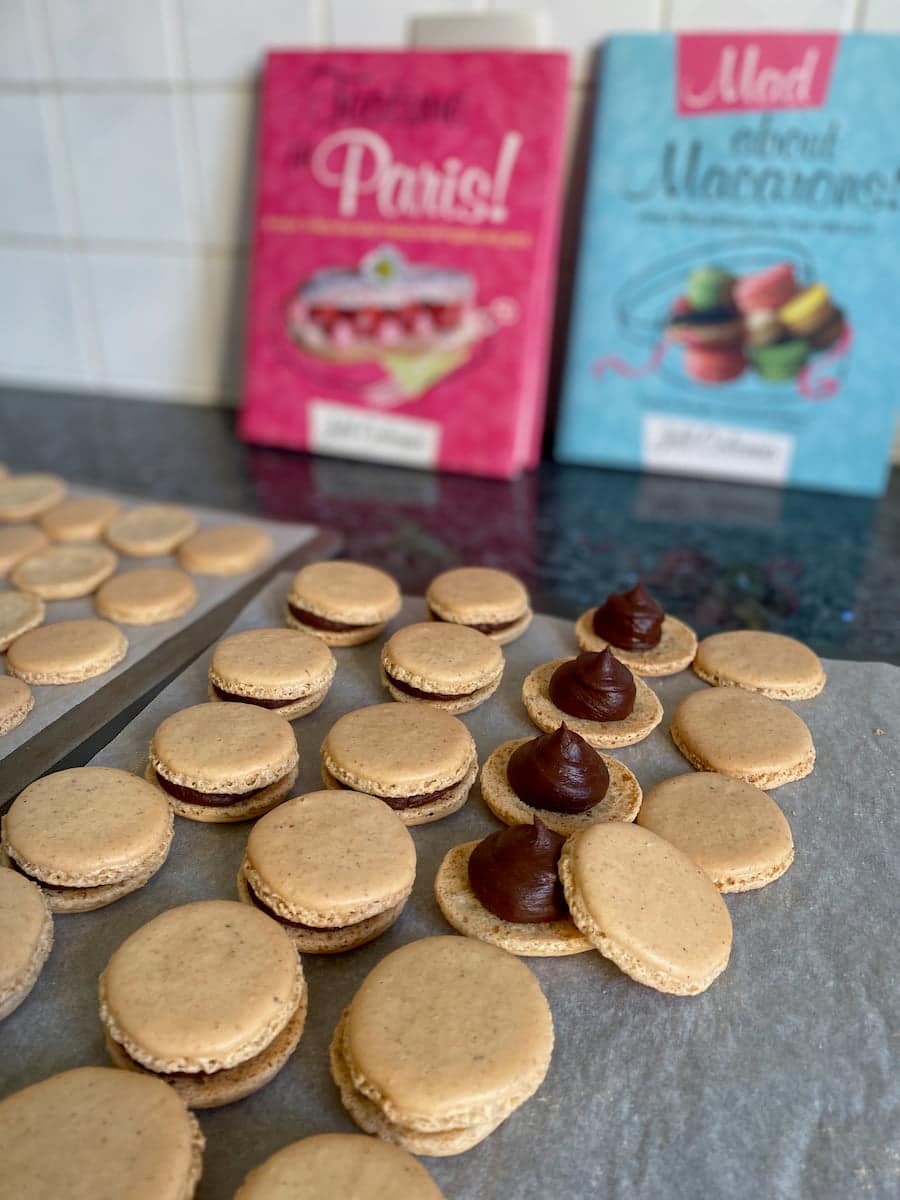 rows of macaron shells with ganache filling