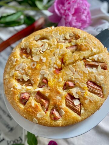 moist cake showing roasted rhubarb and toasted almonds on top