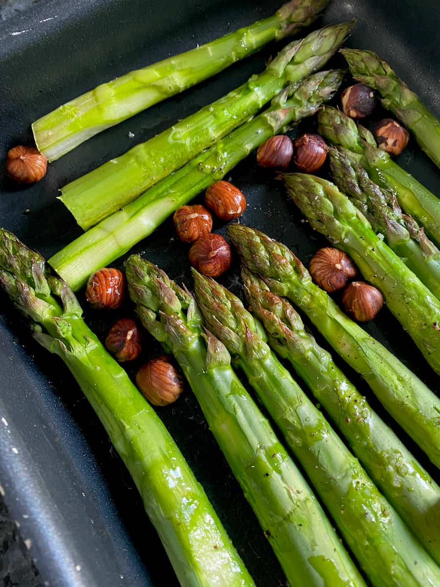 juicy, tender spears of green asparagus just out of the oven, topped with roasted hazelnuts