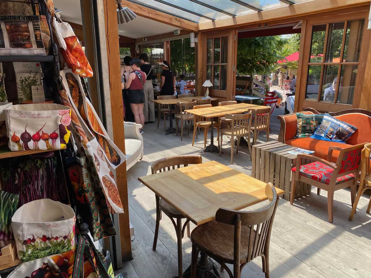 inside a French café in Giverny with armchairs and wooden chairs