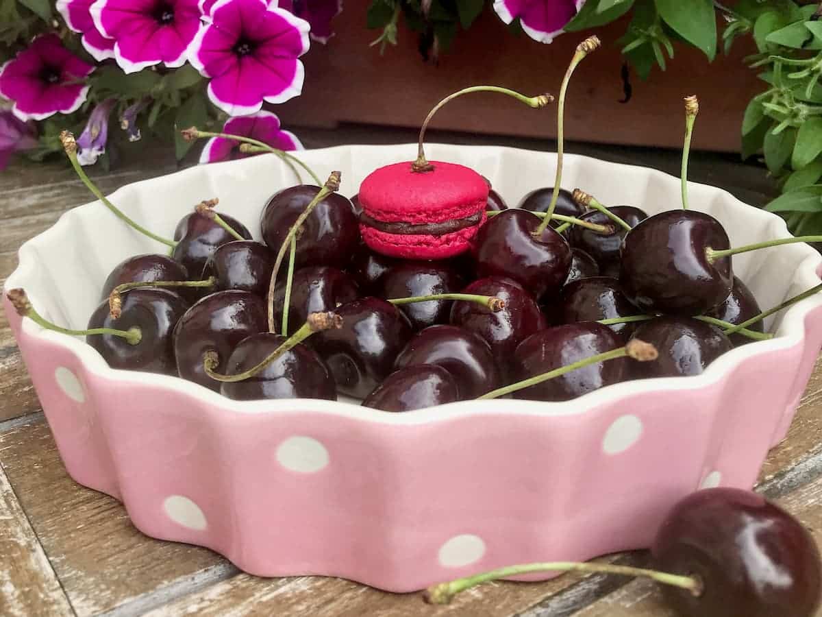 dish of black cherries with a cherry macaron on top