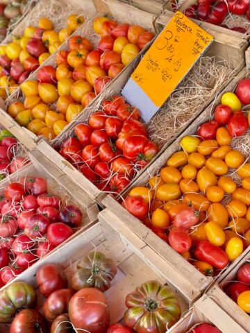 crates of fresh tomatoes in all shapes and colours at the French market in Provence
