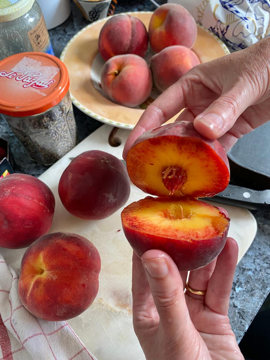 opening up a cling peach cut in two to reveal the stone