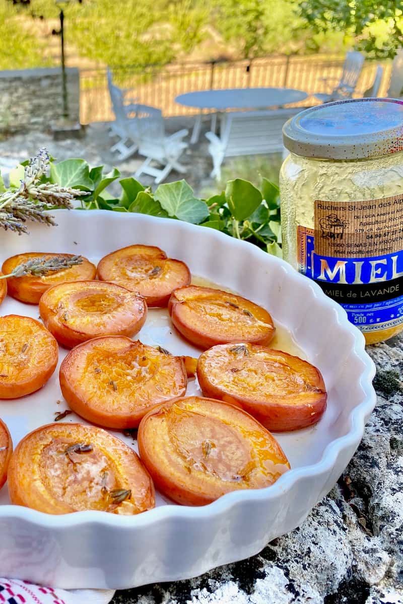 halved apricots baked in a dish with French honey and lavender flowers