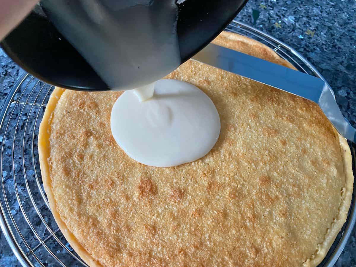 pouring a rum glaze over a French almond cake