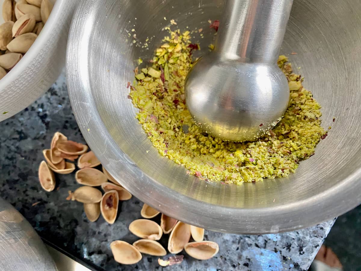 grinding shelled pistachios in a mortar and pestle