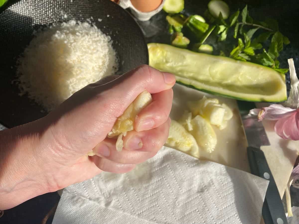 squeezing out excess water from zucchini pulp