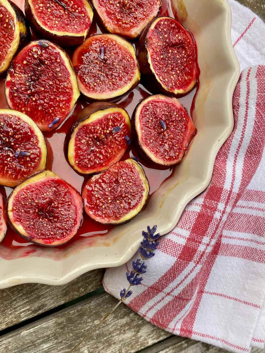 shiny fresh roasted figs, halved in a baking dish in honey and topped with a little lavender