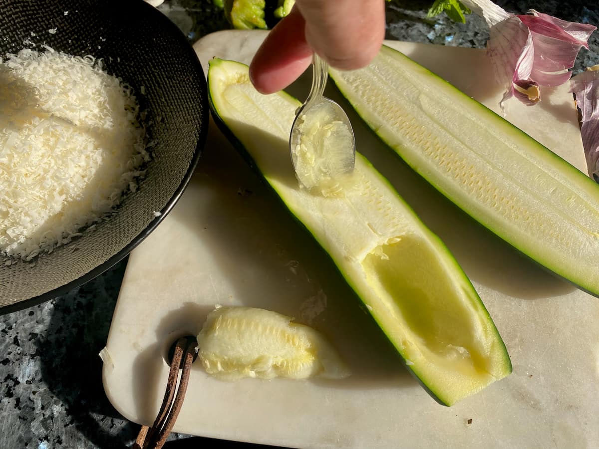 scooping out the flesh of zucchini to make boats