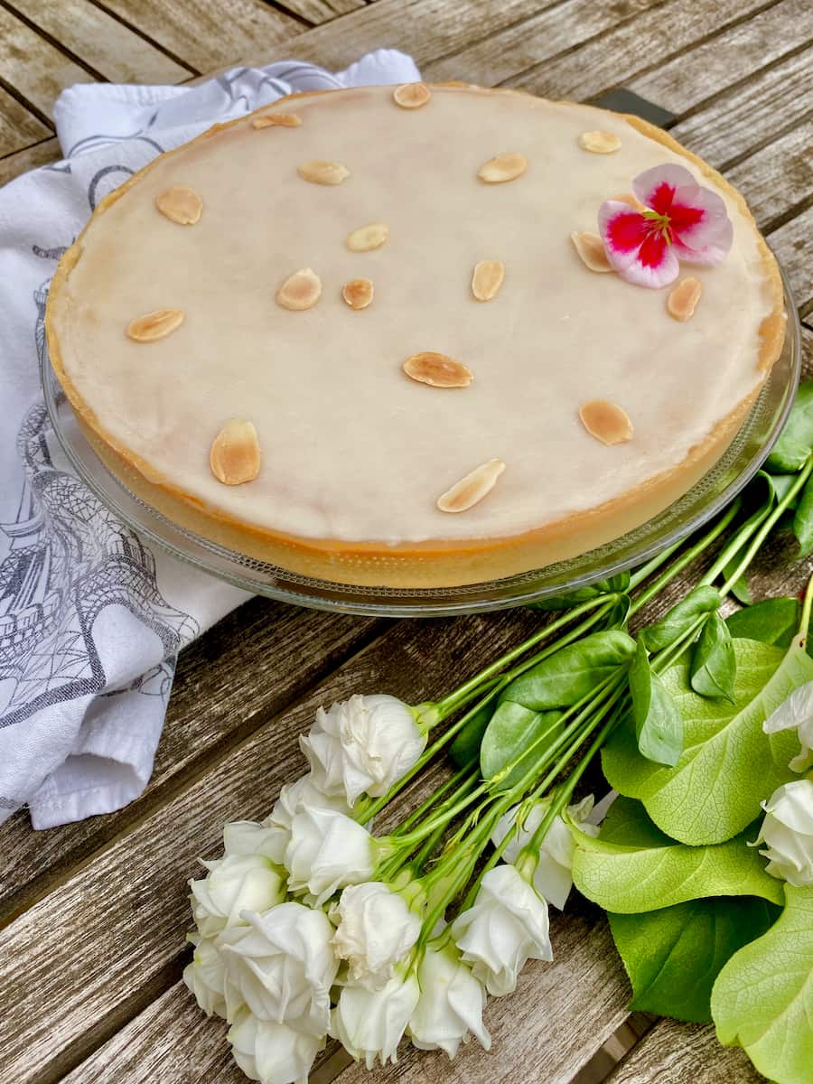 large round almond cake topped with a rum glaze and toasted flaked almonds