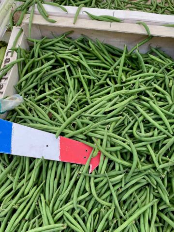 crate of green beans with a French flag at the farmers' market