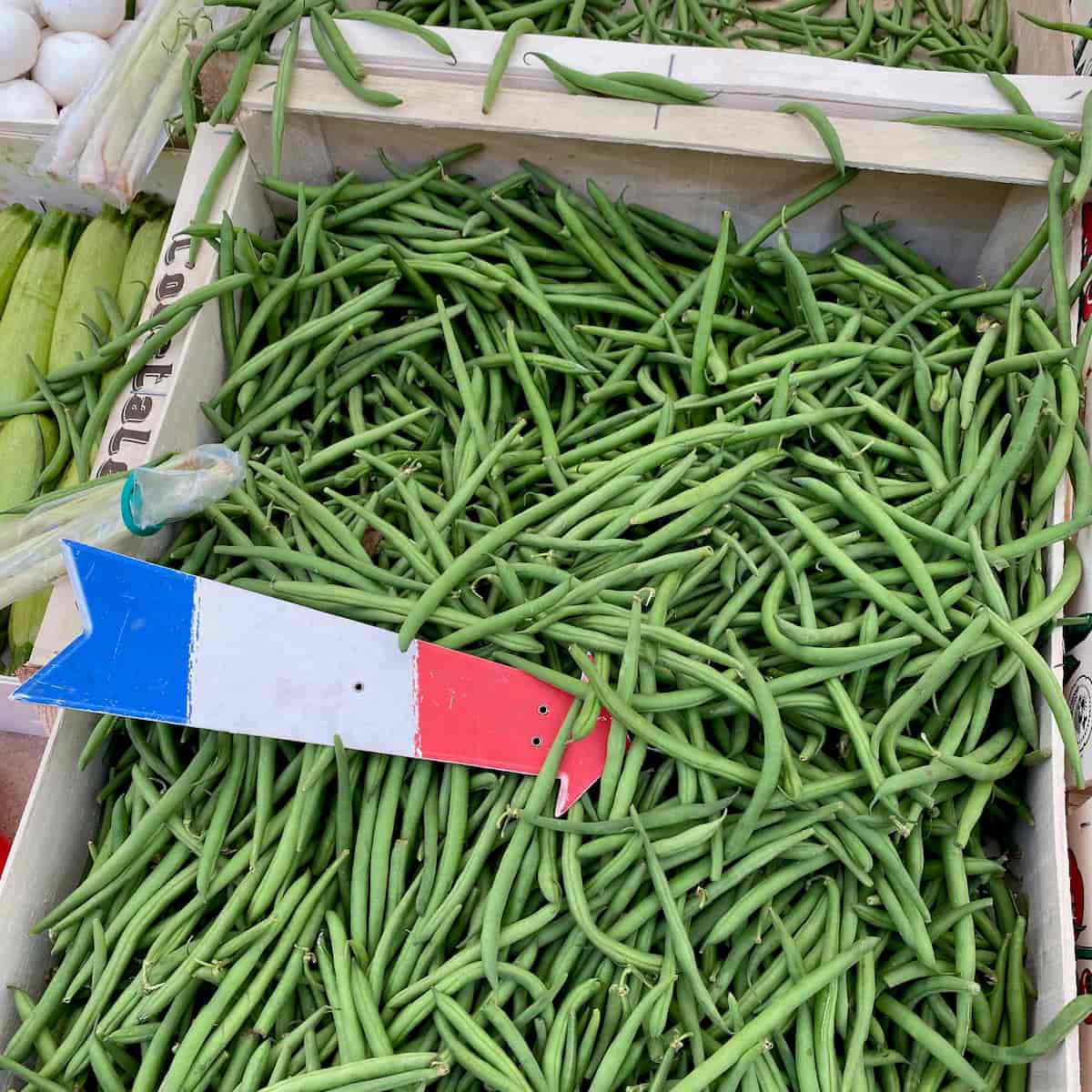 box of fresh green beans with a French flag arrow