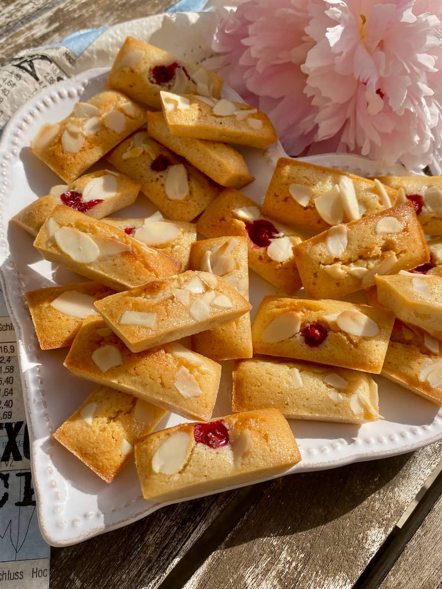 little golden almond financiers topped with flaked almonds and some with redcurrants