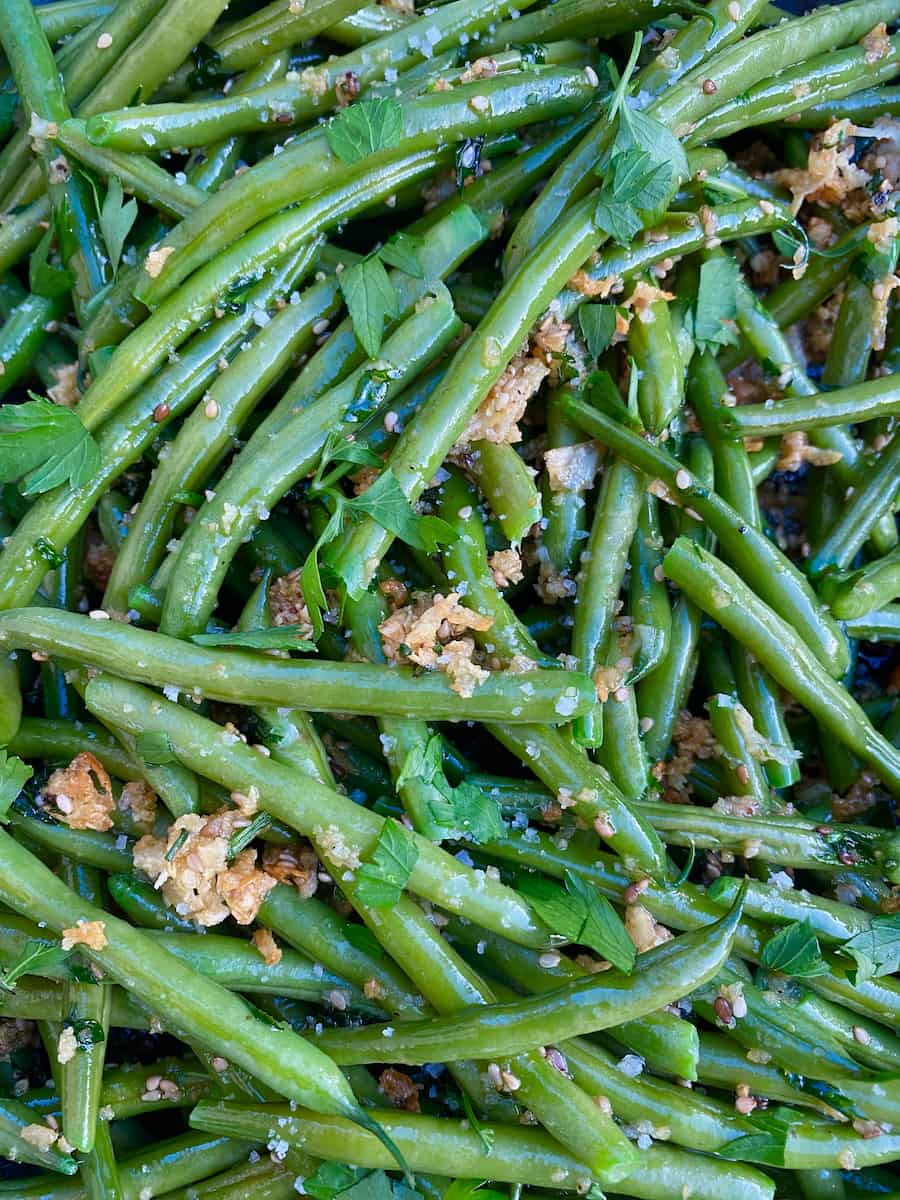 vibrant green beans tossed in oil, butter, toasted breadcrumbs and garlic with seeds 