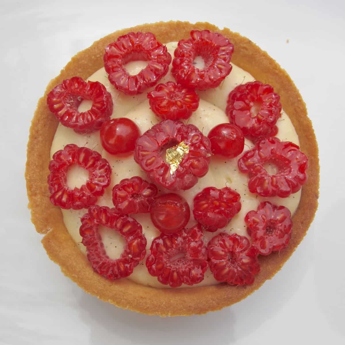 golden crusted French tart with vanilla cream and chopped raspberries