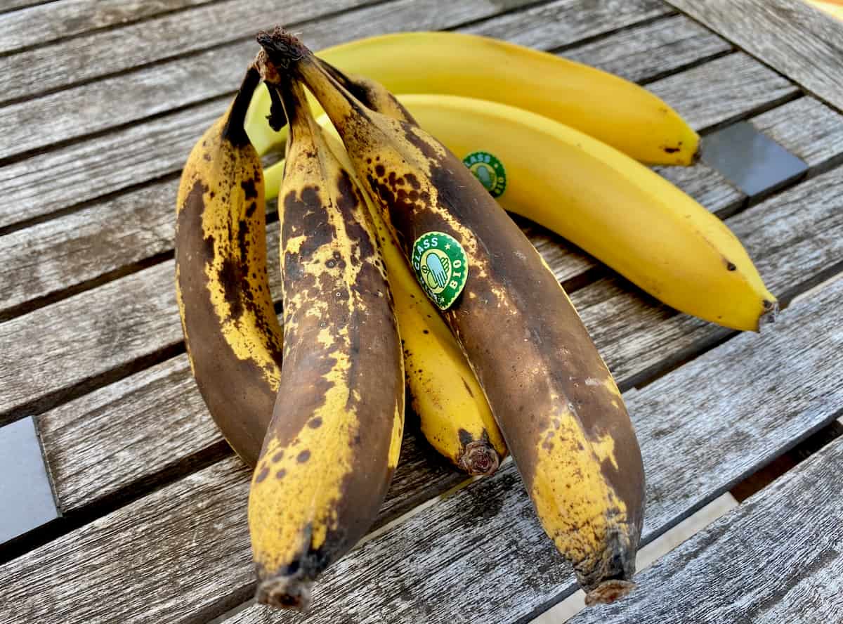 overripe speckled bananas next to ripe yellow bananas