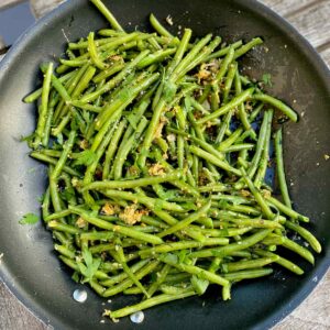 saute pan of fried green beans in garlic and breadcrumbs