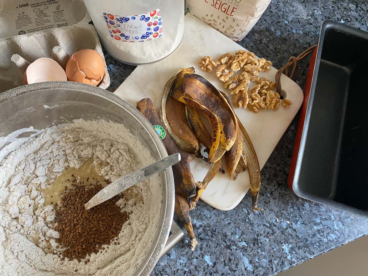 adding coffee powder to the bowl of cake ingredients