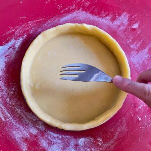 perfect sweet tart dough in the tin, about to be pricked with a fork