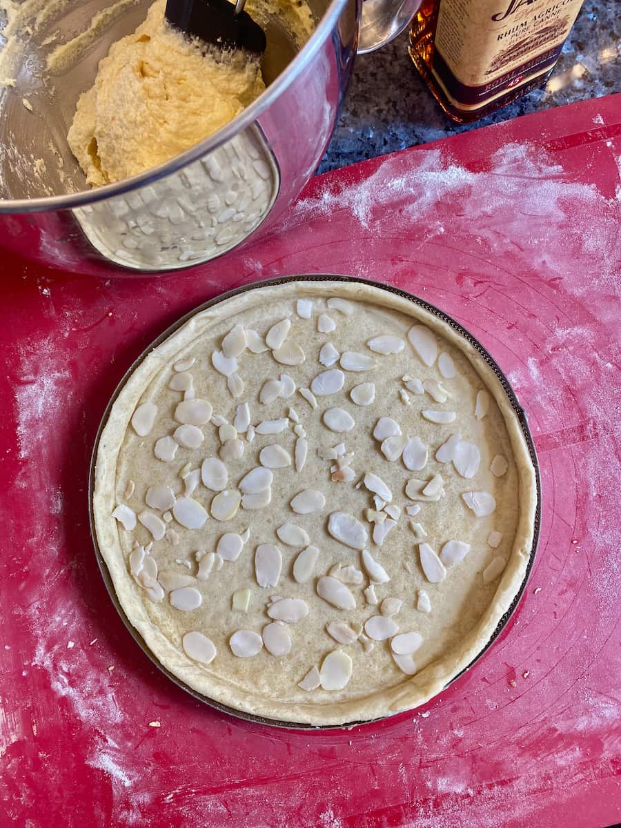 preparing a French almond cake with a baked pastry shell and an almond and rum cream