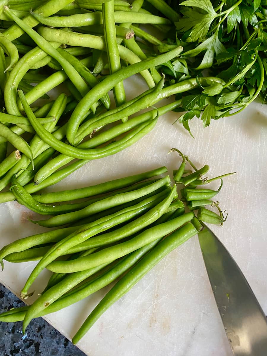 cutting French green beans at the tips or stems with a knife